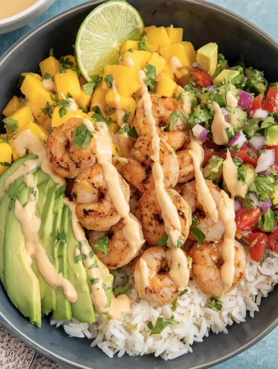 A bowl of shrimp and avocado with mango salsa and lime chili sauce.