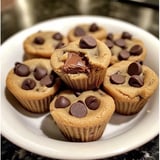 A plate of chocolate chip cookies with chocolate drizzled on top.