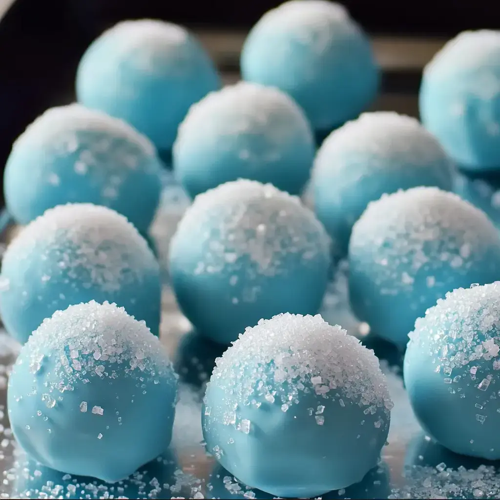 Bright blue bite-sized balls coated in crunchy sugar crystals, all on a tray.