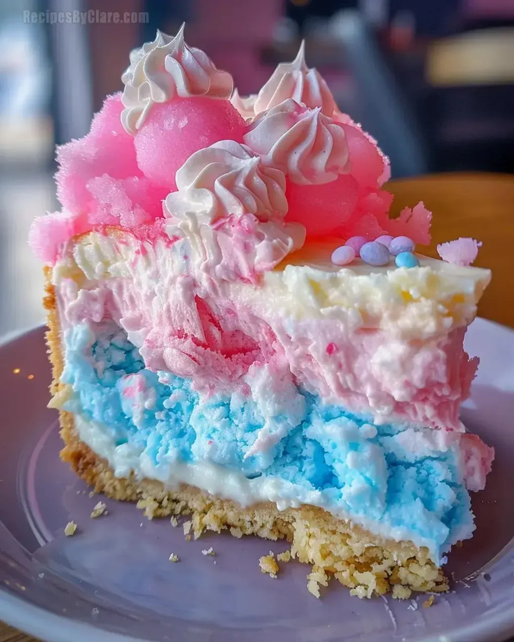 A slice of cotton candy cheesecake on a plate.