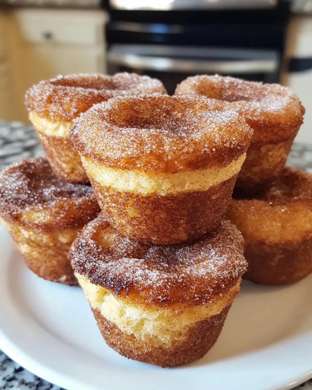 A plate of sugar coated donuts.