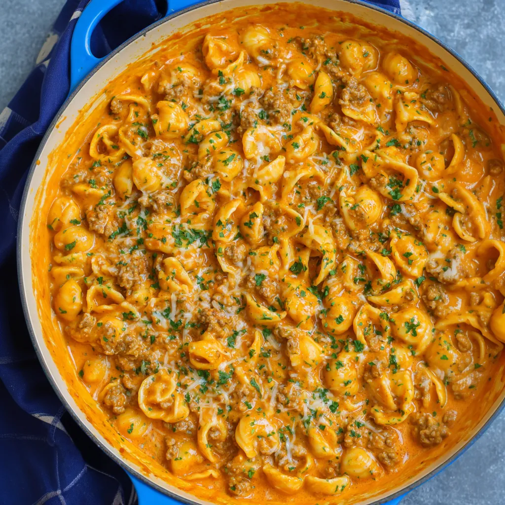A bowl of pasta with meat and cheese.