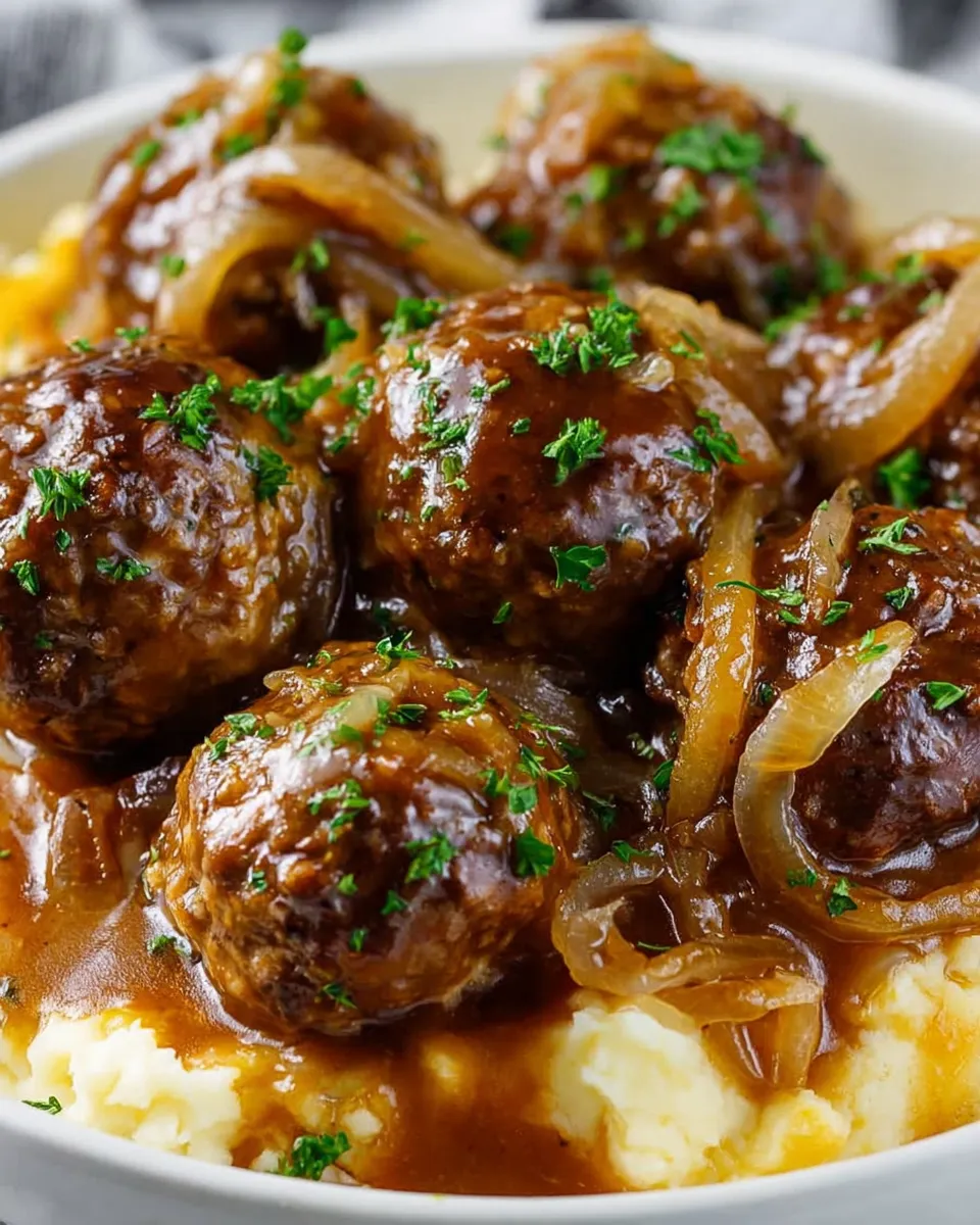 A plate of meatballs covered in a brown sauce.