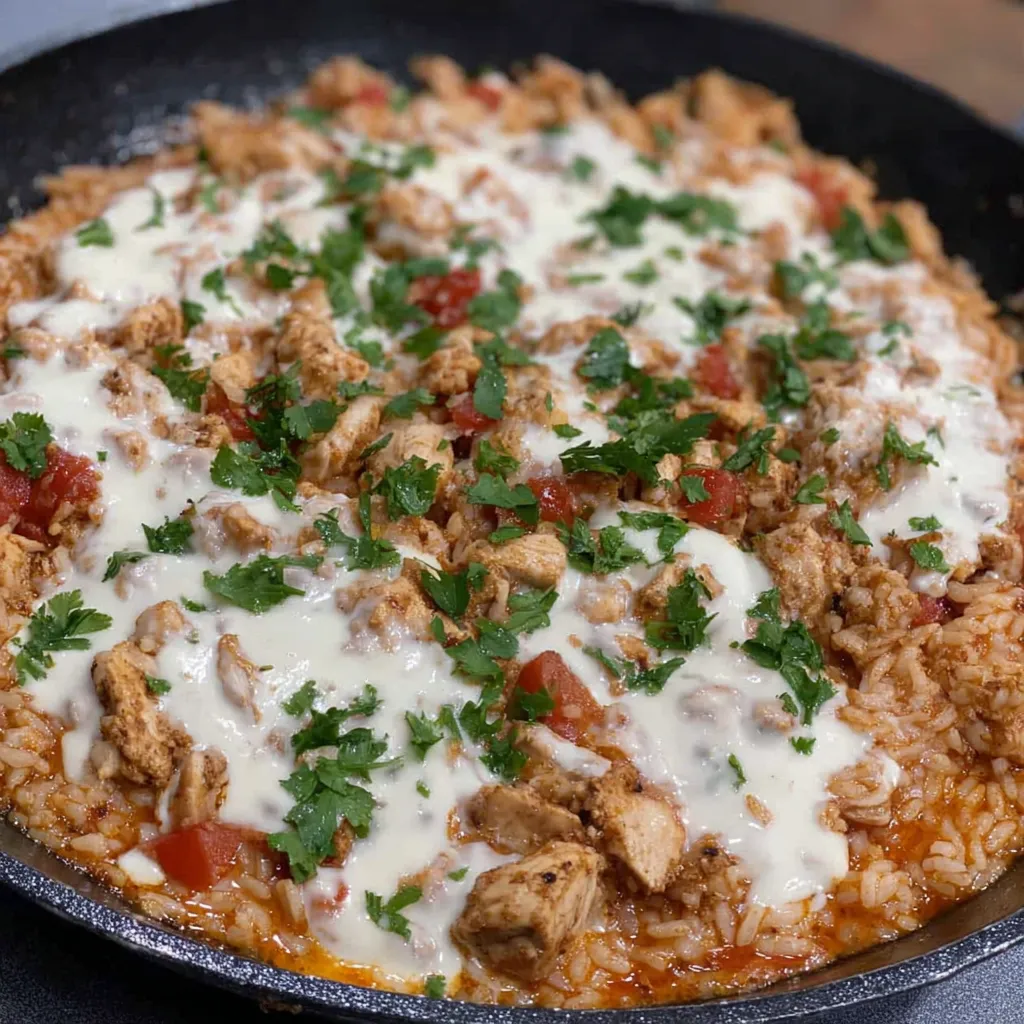 A pan of chicken, cheese and rice.