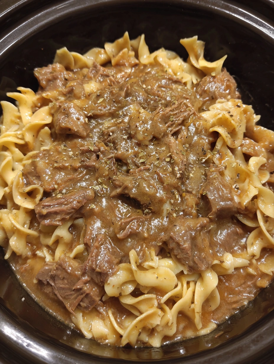 A bowl of beef and noodles in the crockpot.
