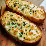 Two slices of bread with cheese on top.