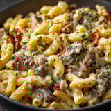 A bowl of pasta with meat and cheese.