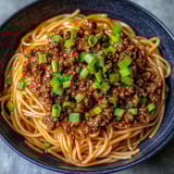 A bowl of Asian ground beef noodles.