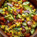 A bowl of avocado, tomato, and corn salad.